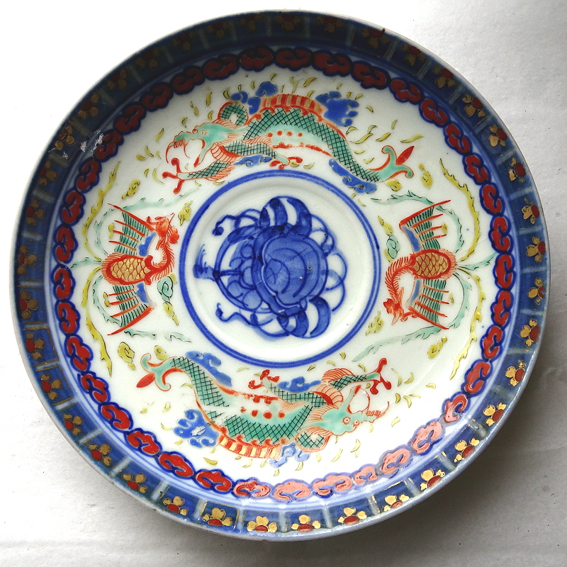 Japanese saucer showing two, two-legged, three-clawed green Dragons, and two phoenixes, with a blue design in the centre and blue pattern edging.